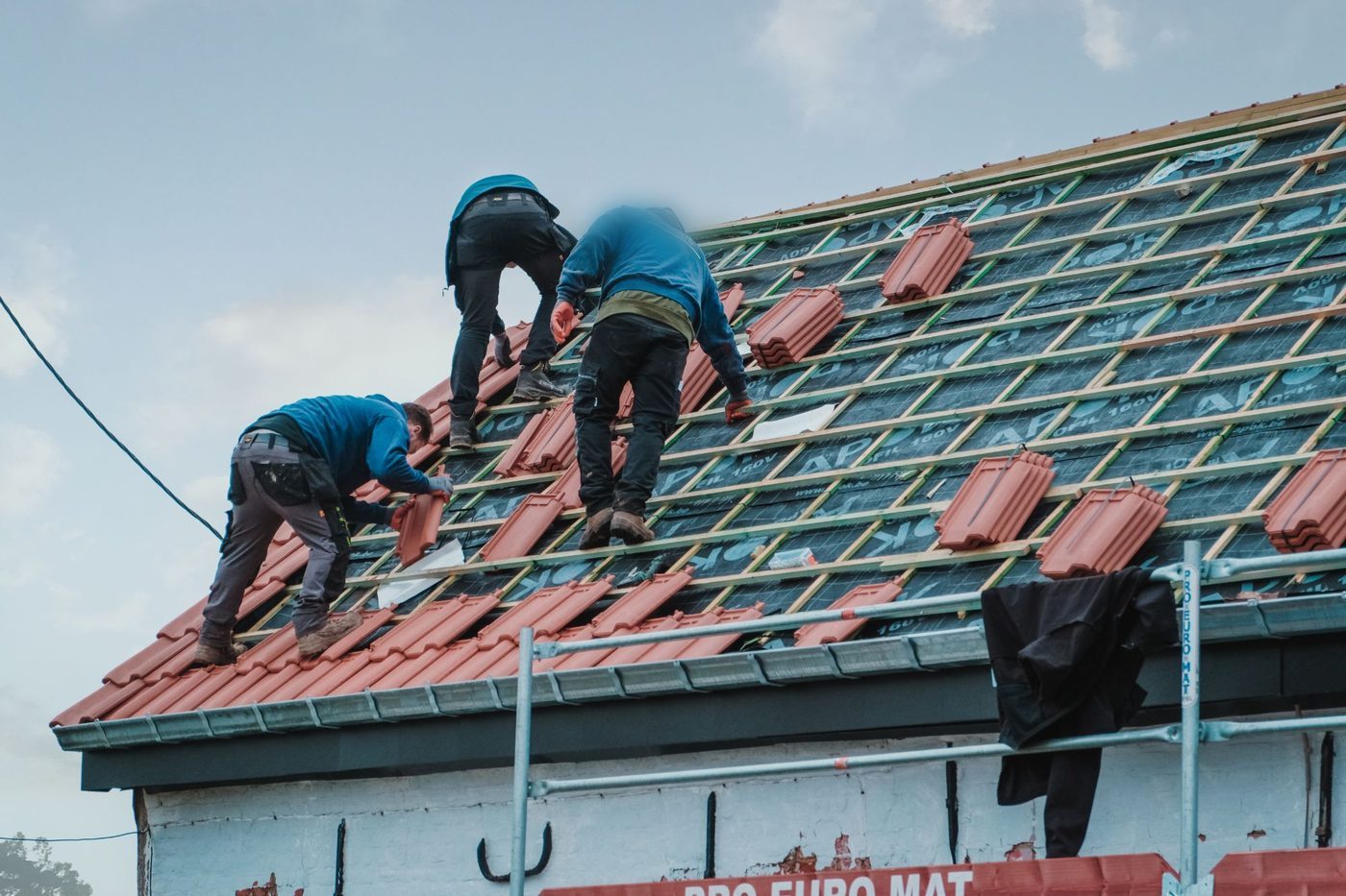 Couvreurs du réseau posant des tuiles sur un chantier en Belgique